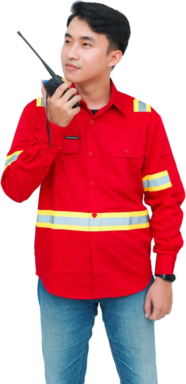 Anggota tim Nusa Safety berkemeja kerja merah dengan pita reflektif, memegang radio komunikasi
